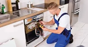Technician testing a kitchen appliance beneath a countertop